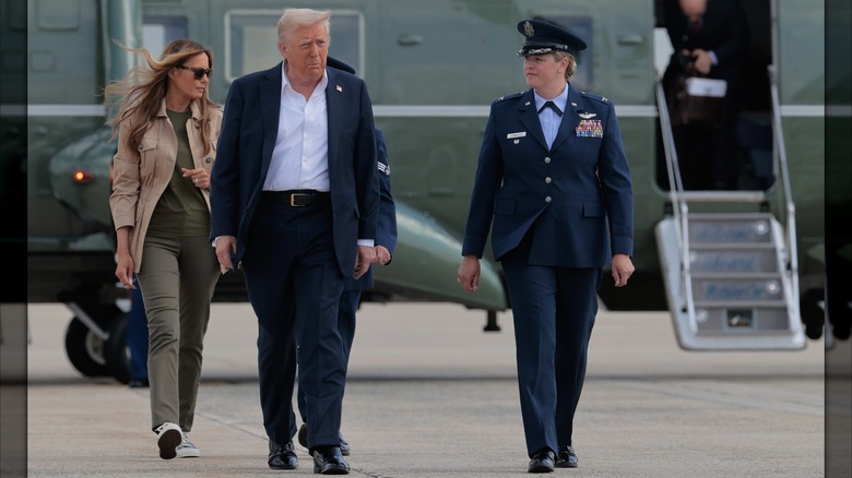 President Donald Trump and first lady Melania Trump walk from the Marine One presidential helicopter to Air Force One before departing for Texas on July 11, 2025