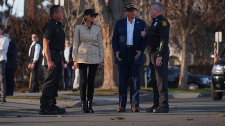 Melania Trump and Donald Trump speaking with law enforcement officials while touring California wildfire damage