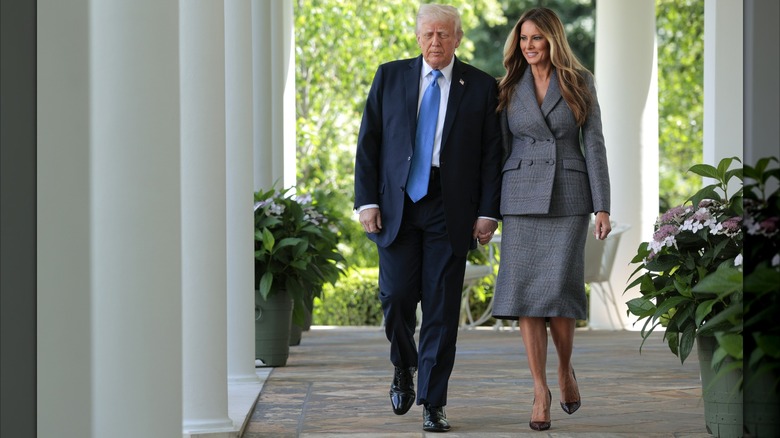 Donald Trump and Melania Trump holding hands as they arrive at the signing ceremony for the "Take It Down Act."