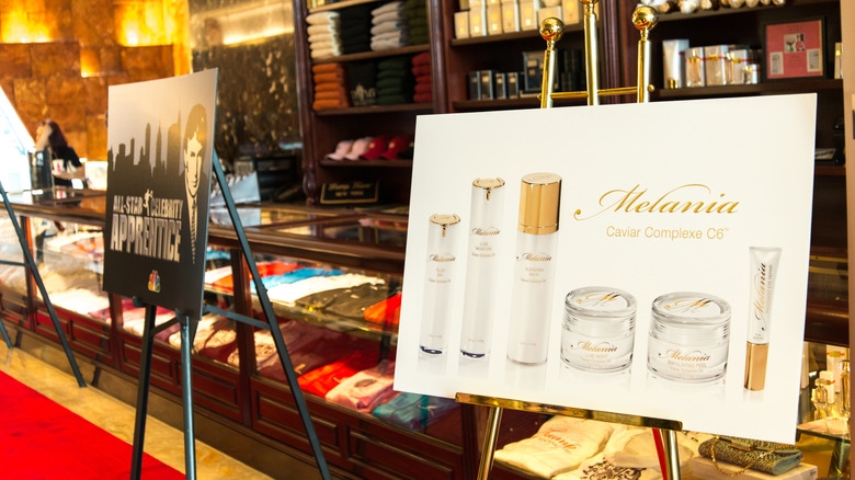A promotional poster for Melania Caviar Complexe C6 skincare products displayed on an easel