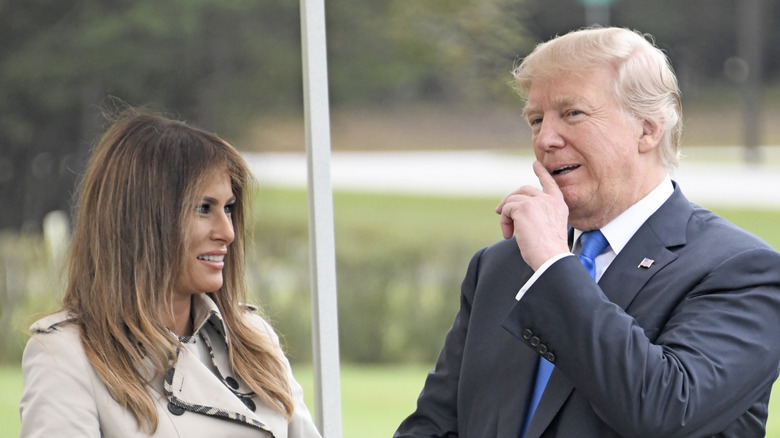 Melania Trump and Donald Trump standing outside in 2017