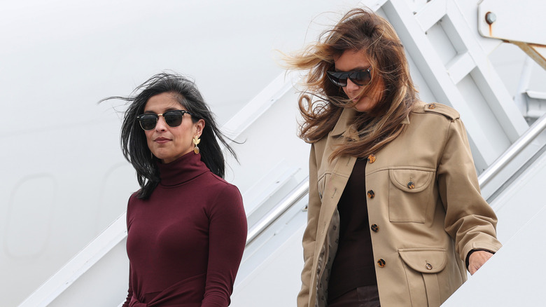 Usha Vance and Melania Trump walking down airplane steps and wearing sunglasses