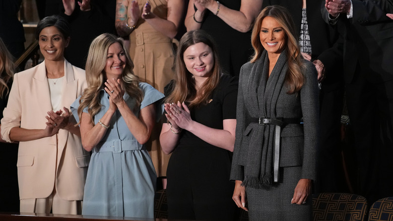 Melania Trump in gray standing with other women