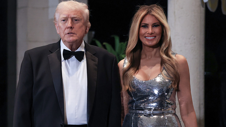 A smiling Melania Trump standing next to a dazed-looking Donald Trump