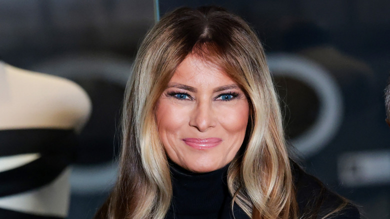 Melania Trump smiling in front of inaugural dress
