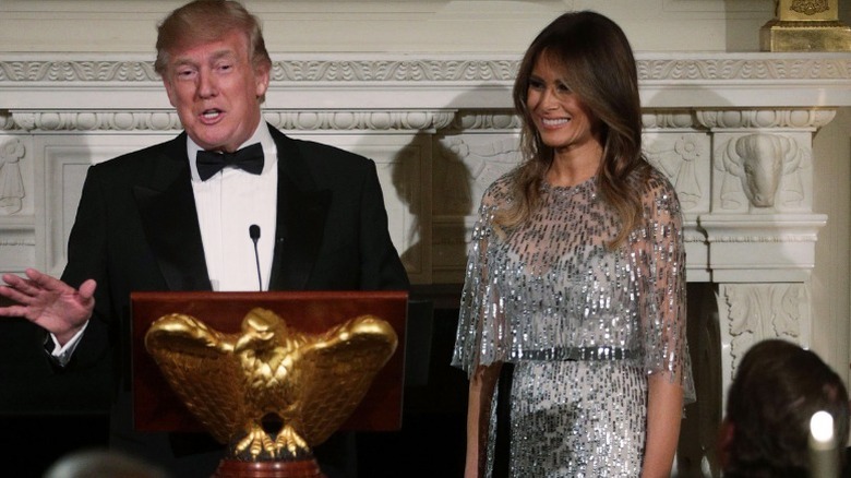 Donald Trump speaks as Melania Trump listens during a reception