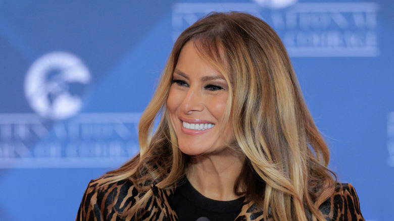 Melania Trump smiling at an audience while speaking on stage