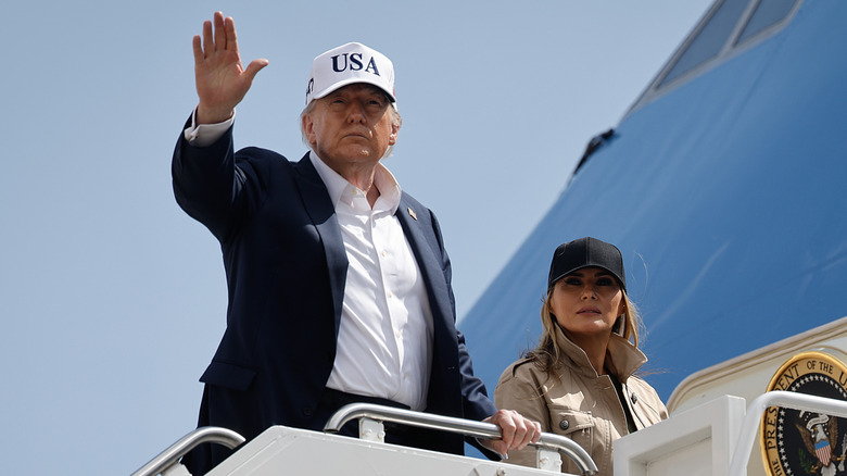 Donald Trump waving with Melania Trump behind him