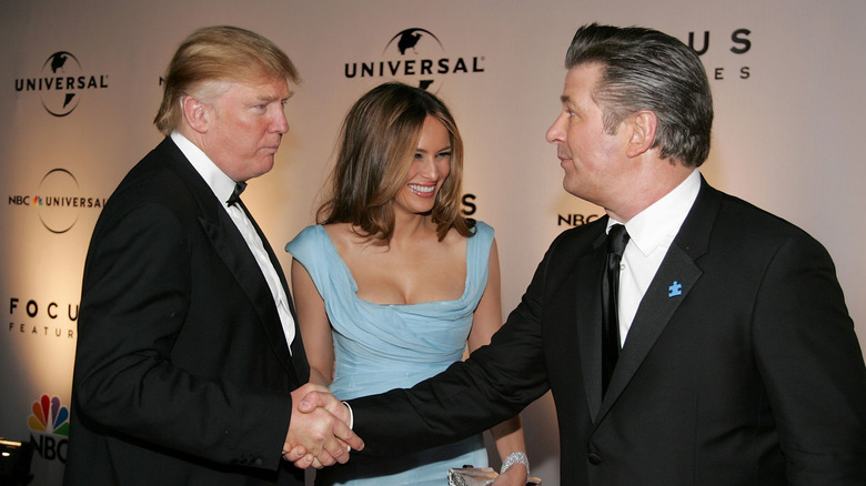 Donald Trump shaking hands with Alec Baldwin while Melania smiles and looks on