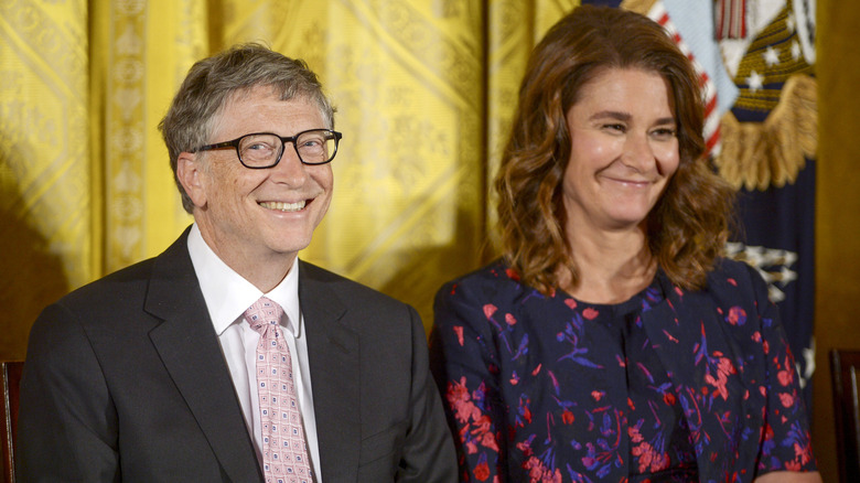 Bill Gates and Melinda Gates smiling while looking in two different directions
