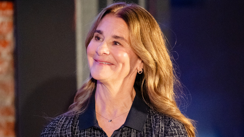 Melinda French Gates smiling in a patterned, collared black dress