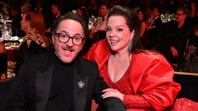 Ben Falcone and Melissa McCarthy smiling at a benefit dinner