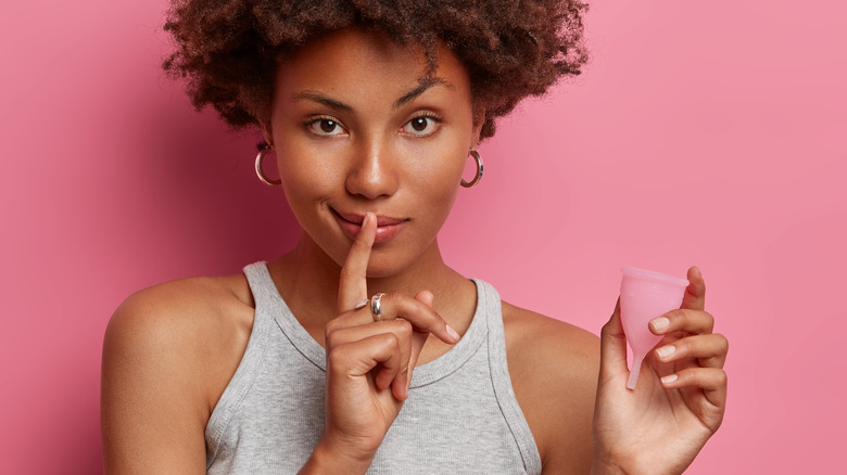 Black woman holding a menstrual cup