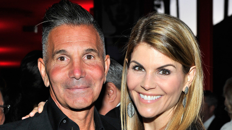 Lori Loughlin with her hand on Mossimo Giannulli's shoulder