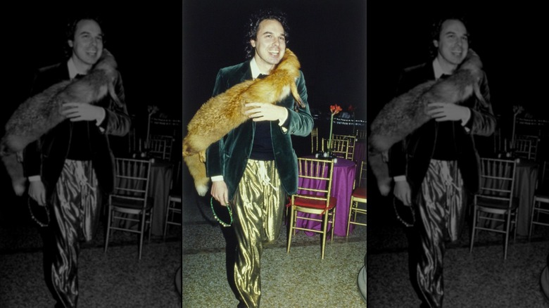 Unidentified party guest at New York's Metropolitan Museum of Art gala wearing gold lamé pants, green velvet jacket, black sweater, and a fur stole