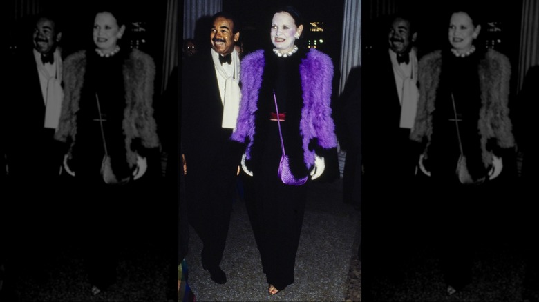 Gloria Vanderbilt (right) wearing a Chanel purple and black fur jacket over a black Givenchy gown with Bobby Short at the Metropolitan Museum of Art Gala