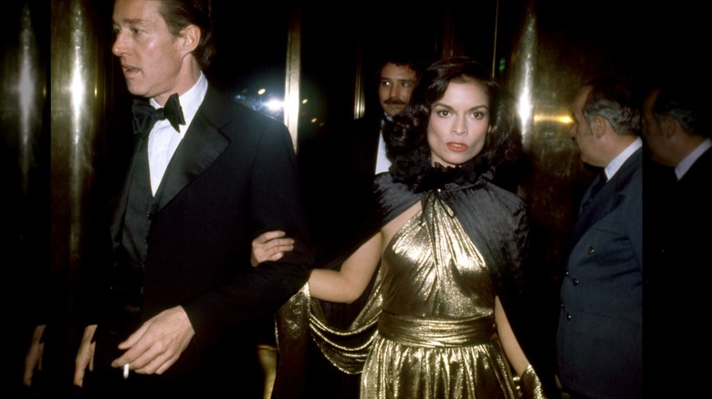 American fashion designer Roy Halston Frowick and Bianca Jagger attending the Metropolitan Museum of Art Costume Institute Exhibition with linked arms
