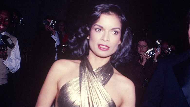 Bianca Jagger attending the Met Gala in 1979 in a gold halter-neck dress