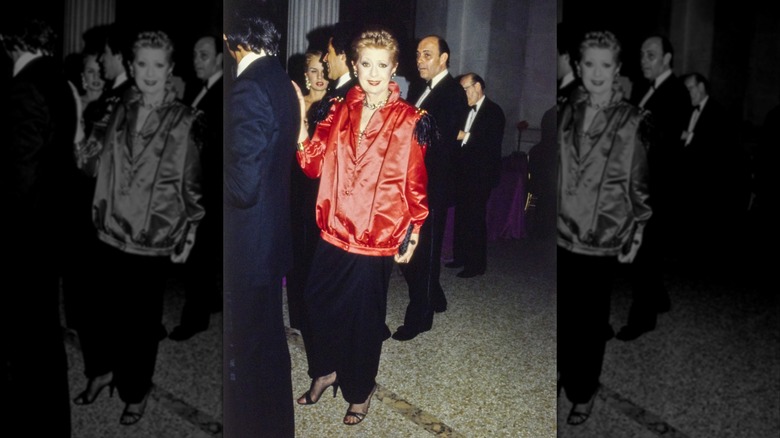 Eve Orton in an Yves Saint Laurent red satin jacket and black pants at the 1979 Met Gala