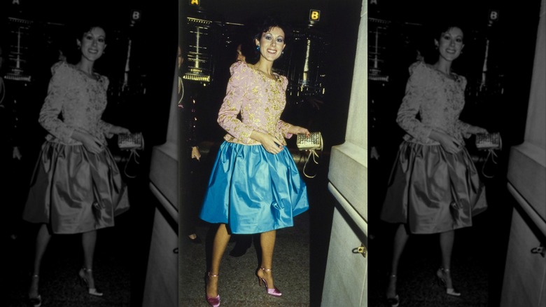 Unidentified woman wearing an Oscar de la Renta ensemble consisting of a knee-length turquoise skirt and a pink and gold jacket at the 1979 Met Gala