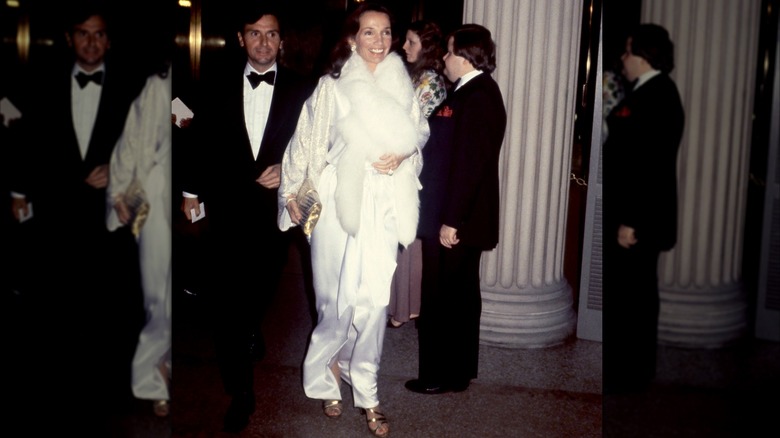 Peter Tufo and L Radziwill wearing a white satin gown and fur stole at the 1978 Met Gala