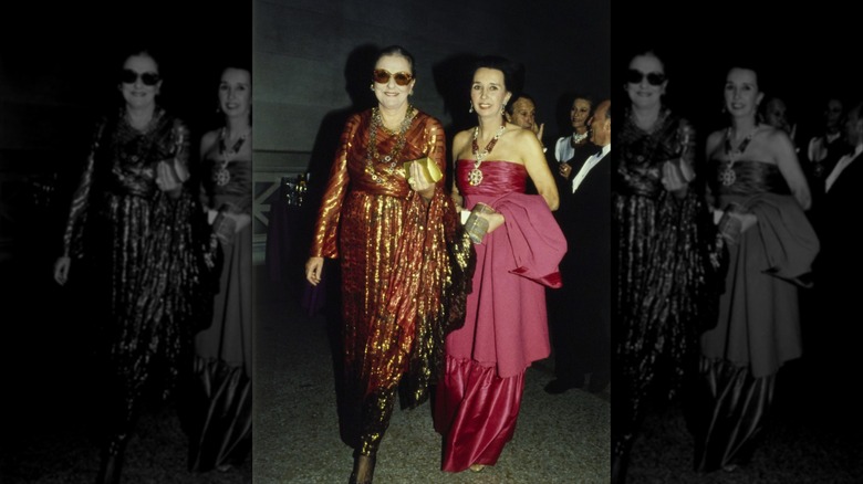 Slim Keith wearing a rust-colored Bill Blass gown (left) with metallic gold threads next to an unidentified woman in a strapless pink gown (right) at the Met Gala
