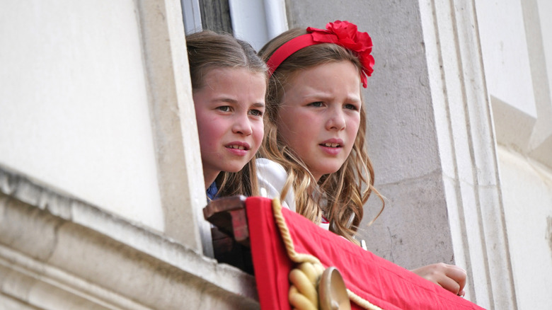Princess Charlotte and Mia Tindall watch the Trooping of the Colour from a window