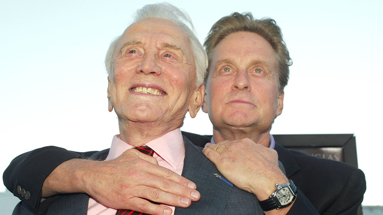 Michael Douglas with his arms around Kirk Douglas
