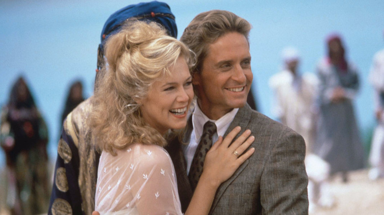 Kathleen Turner hugging Michael Douglas while they smile