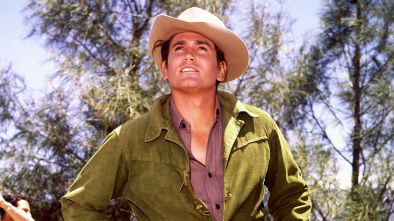 Michael Landon wearing a cowboy hat and green jacket on the set of "Bonanza."