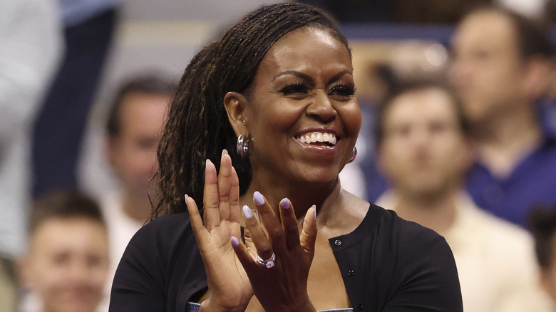 Michelle Obama smiling and clapping