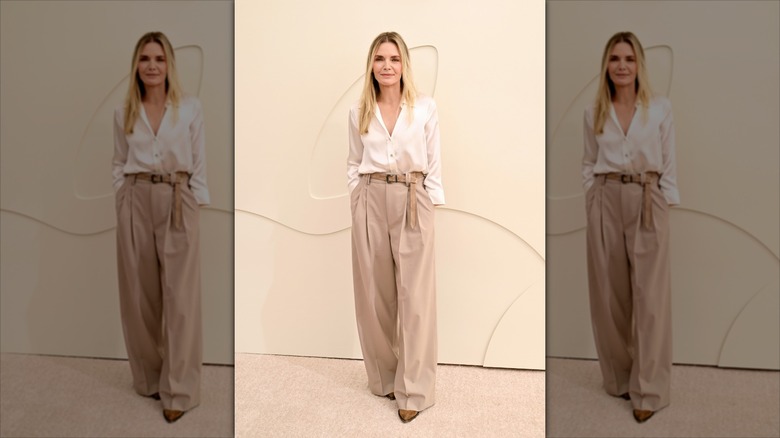 Michelle Pfeifer in a slightly sheer white baggy blouse tucked into khaki baggy pants on a red carpet