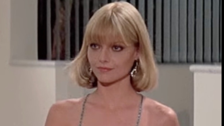 Michelle Pfeiffer with short blond bob and bangs in spaghetti strap dress in "Scarface"