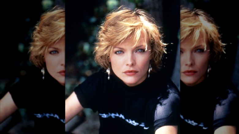 Michelle Pfeiffer with short reddish hair unsmiling in a dark shirt with stripe