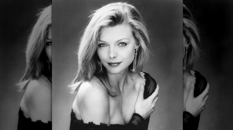 Black and white photo of Michelle Pfeiffer with off the shoulder gown and side parted hair