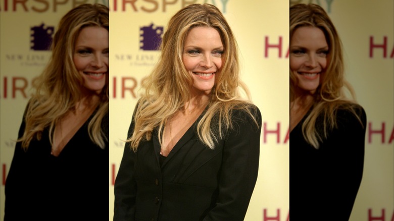 Michelle Pfeiffer in black blazer with big blonde hair smiling