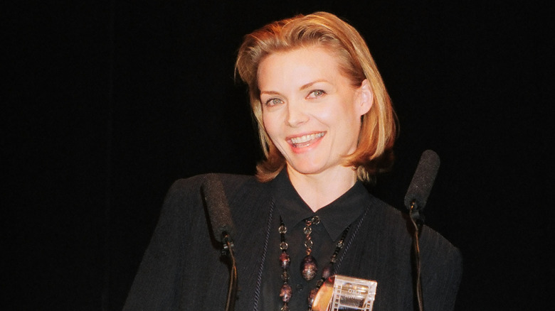 Michelle Pfeiffer with short higlighted lob wearing black shirt and big necklace