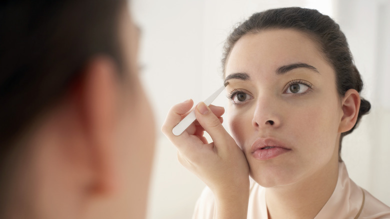 woman touches up her eyebrows