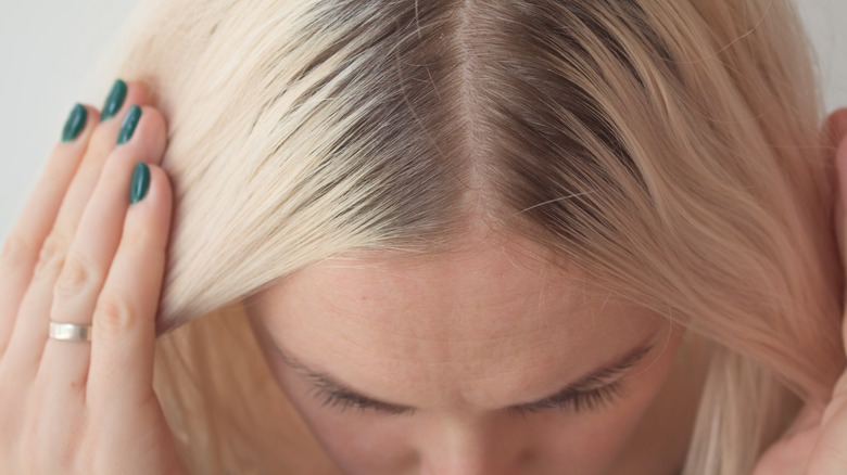 Blonde haired woman parting her hair