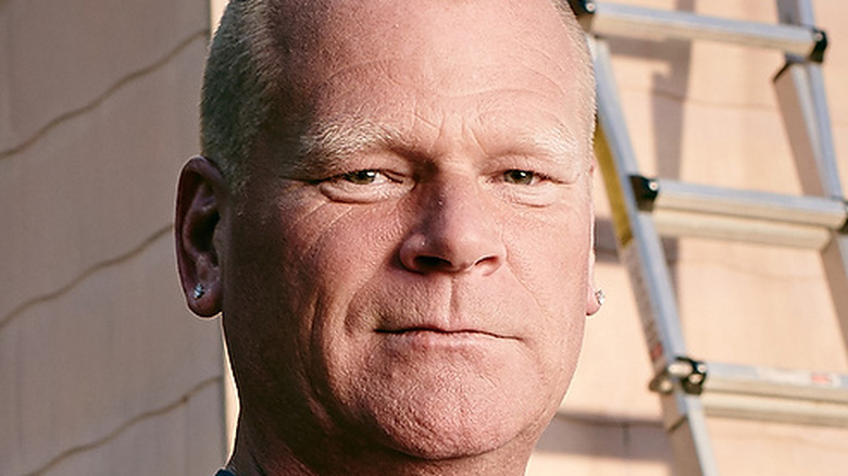 Mike Holmes standing in front of a house