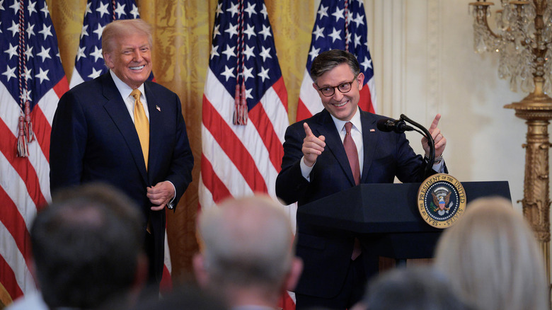 Mike Johnson and Donald Trump smiling and celebrating together