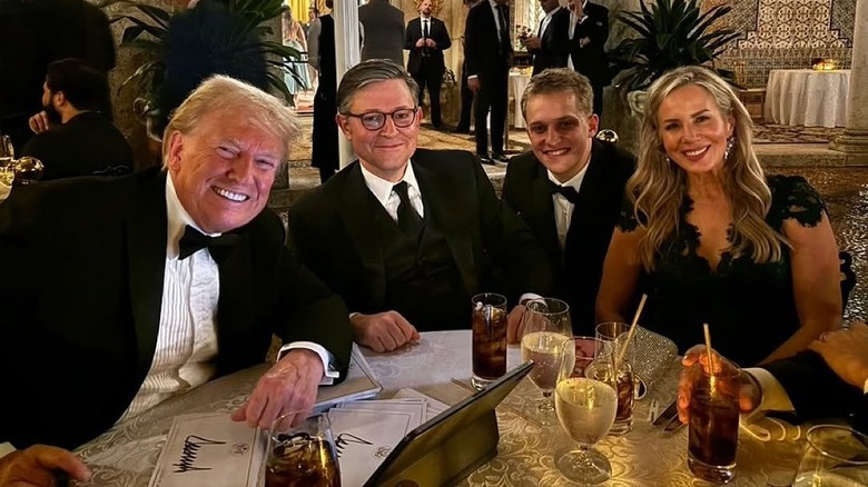 Donald Trump, Mike Johnson, another man, and Kelly Johnson pose at a Mar-a-Lago event in November 2024.