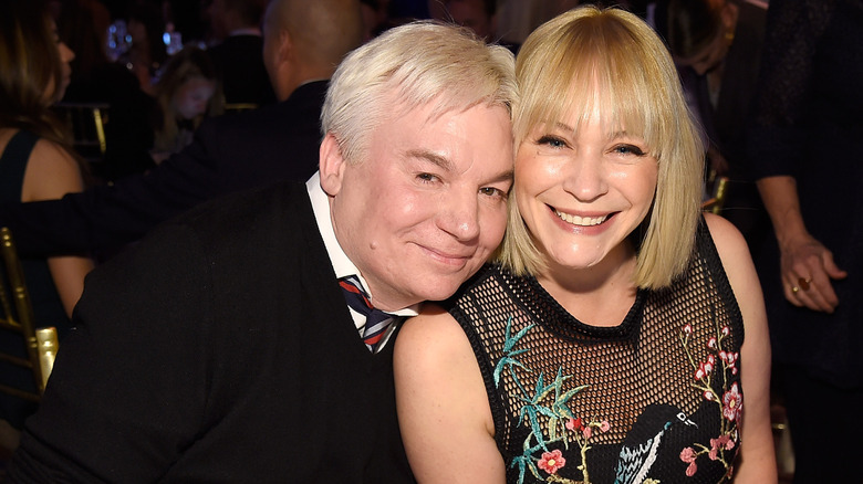 Mike Myers and Kelly Tisdale smiling, their heads together