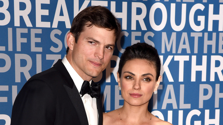 Ashton Kutcher and Mila Kunis posing for photos
