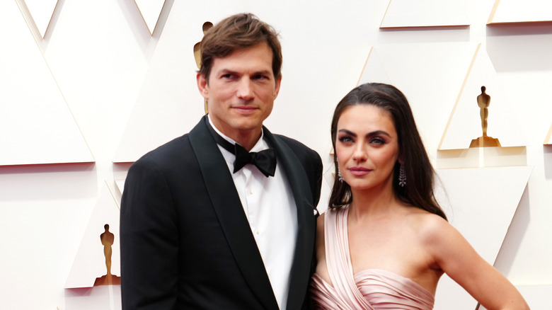 Ashton Kutcher and Mila Kunis posing for photos