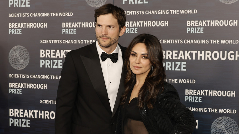 Mila Kunis and Ashton Kutcher posing for photos