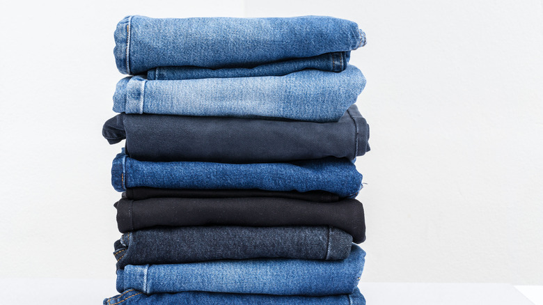 Stacked jeans against white background