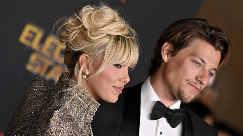 Millie Bobby Brown with blonde hair standing beside Jake Bongiovi.