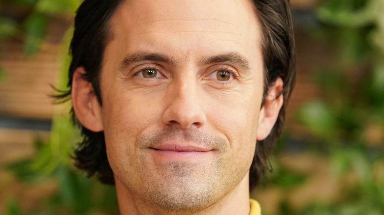 Milo Ventimiglia smiling in yellow at an event