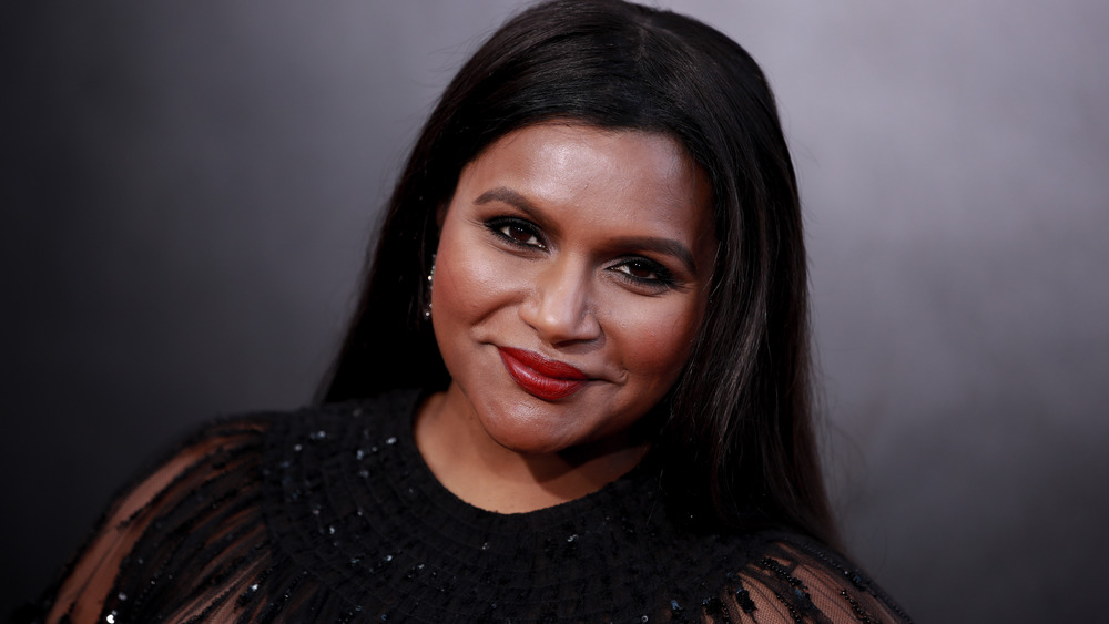 Mindy Kaling smiling in a black dress